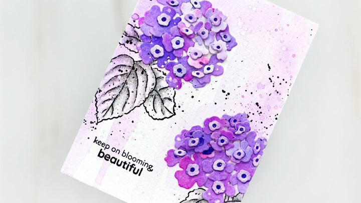 Close-up of Altenew Mini Delight Blooming Lantana die-cut flowers arranged on watercolor cardstock with delicate color variation and subtle shimmer.