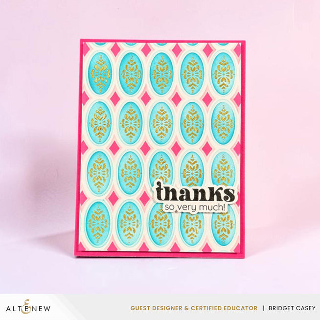 Altenew Heirloom Filigree stencil set with enchanted gold shimmer paste on ruby red cardstock in a Bridget Casey case.