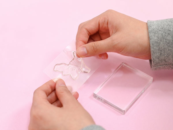Peel the clear stamp from the sheet and press on an acrylic block or stamping tool.