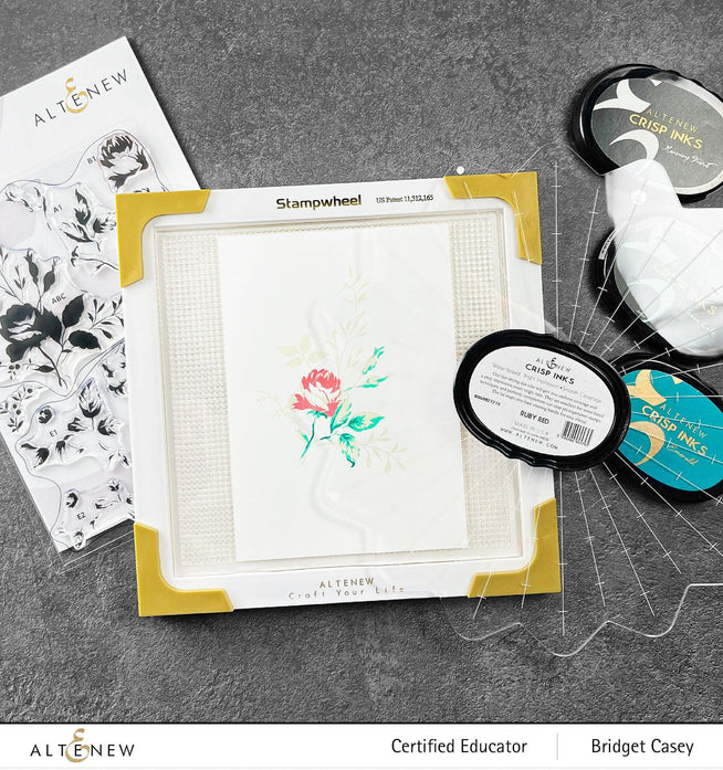 Altenew Stampwheel 1.0 Meta tool with colorful stamp designs and wheel for creative stamping projects.